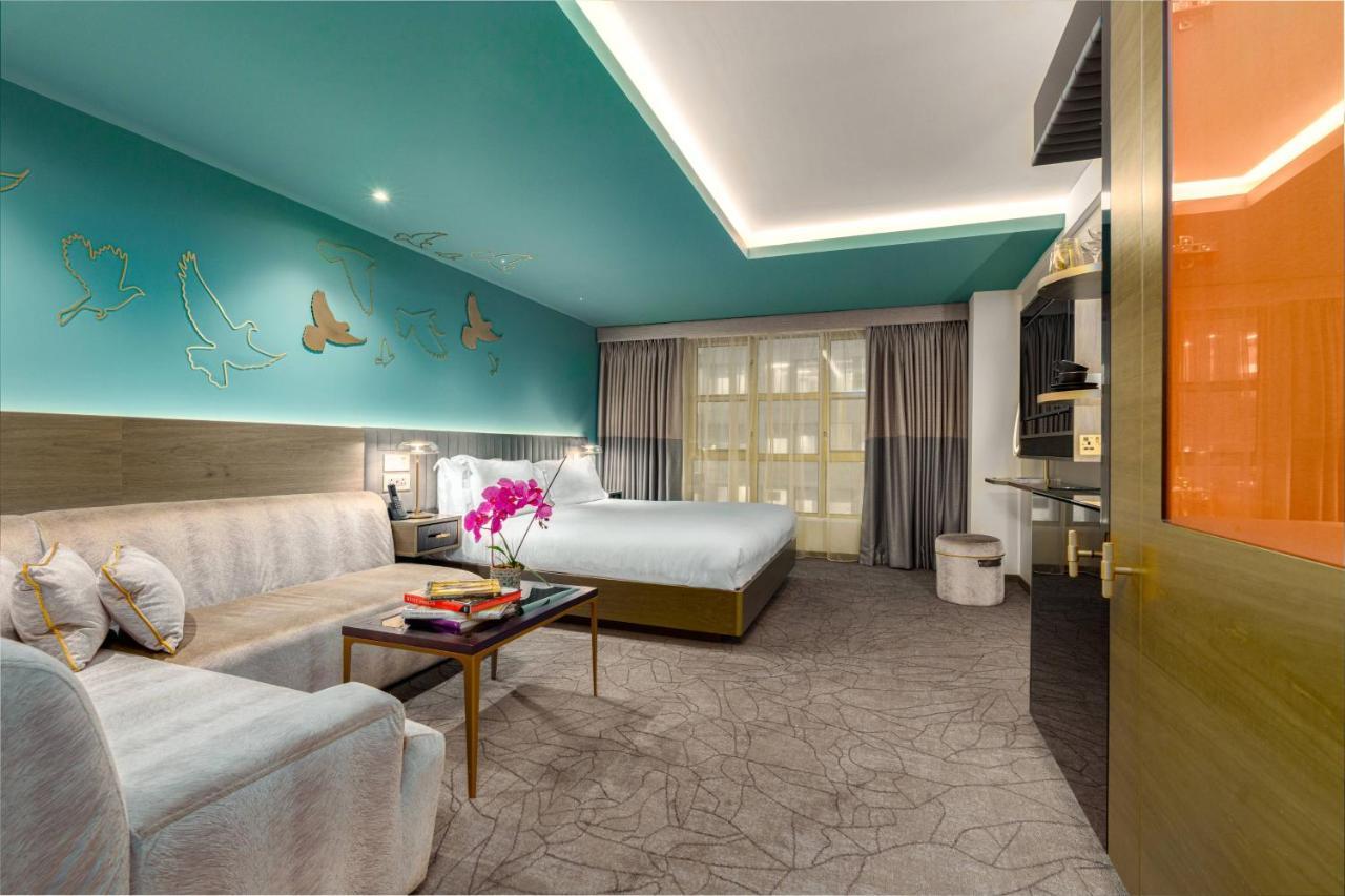 Middle Eight - Covent Garden - Preferred Hotels And Resorts 런던 외부 사진 The photo shows a modern hotel room featuring a blend of comfort and style. The room has a light-colored floor with a textured design, and the walls are adorned with a vibrant turquoise accent wall that features decorative butterfly motifs. 

There i