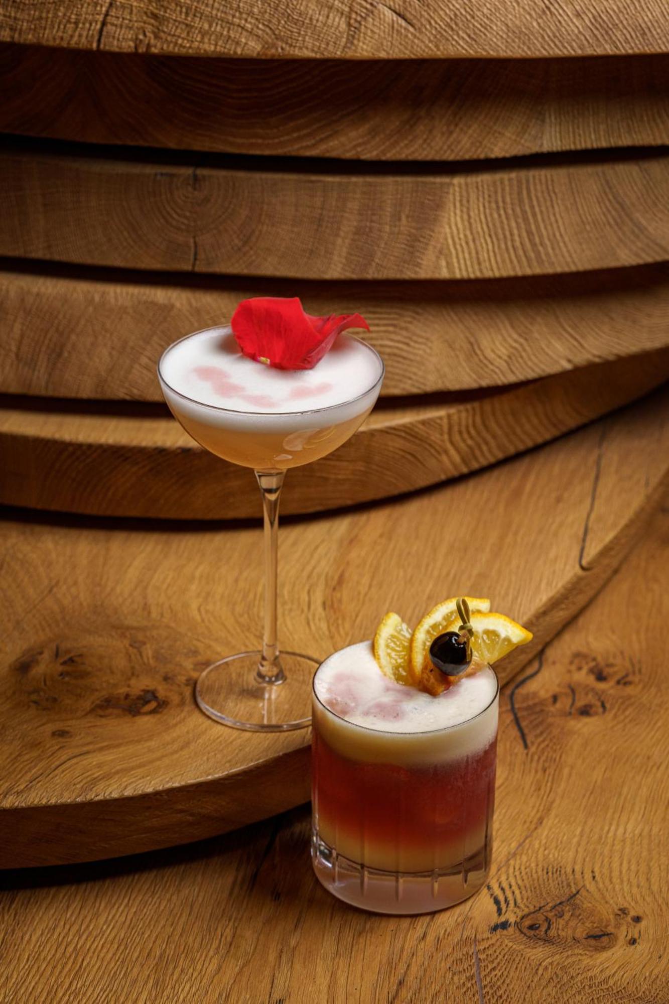 Middle Eight - Covent Garden - Preferred Hotels And Resorts 런던 외부 사진 The photo showcases two elegant cocktails arranged against a warm wooden backdrop. 

1. The first cocktail is served in a classic coupe glass. It has a frothy, pale hue, topped with a vibrant red flower petal, adding a touch of sophistication. 

2. T